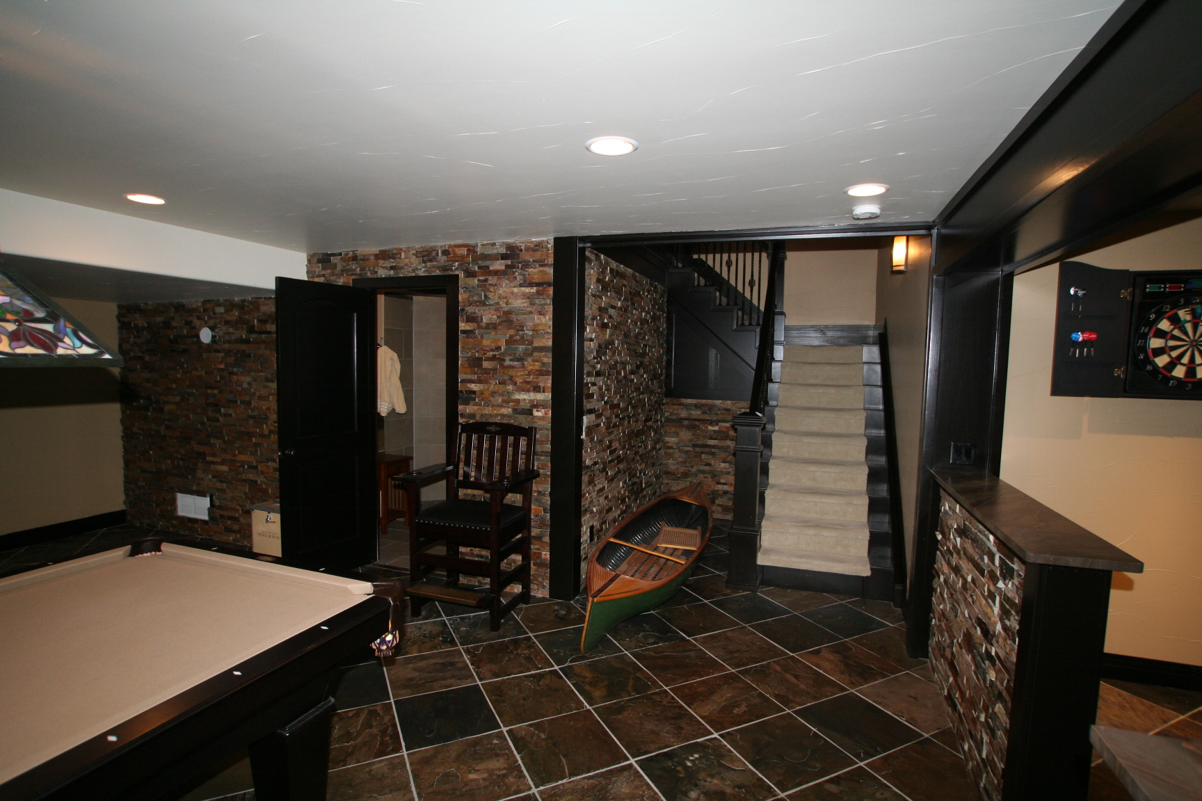 Finished basement game room with stone walls